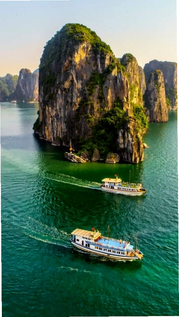 Du thuyền nhỏ giữa vịnh biển xanh và núi đá