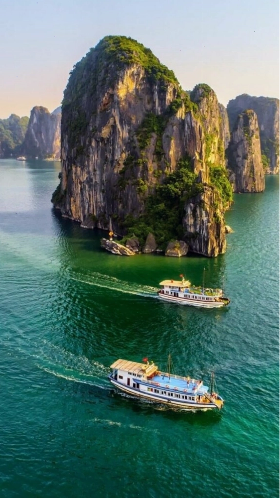 Du thuyền nhỏ giữa vịnh biển xanh và núi đá, mang đến cảm giác thư thái cho hình nền điện thoại